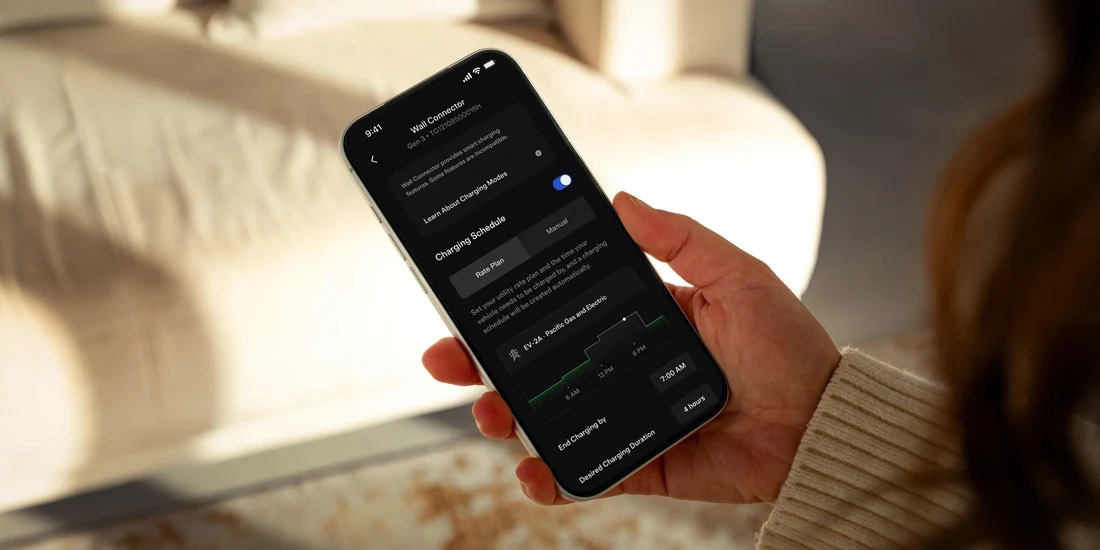 Person using the Tesla app to view Wall Connector charging controls and a charging schedule